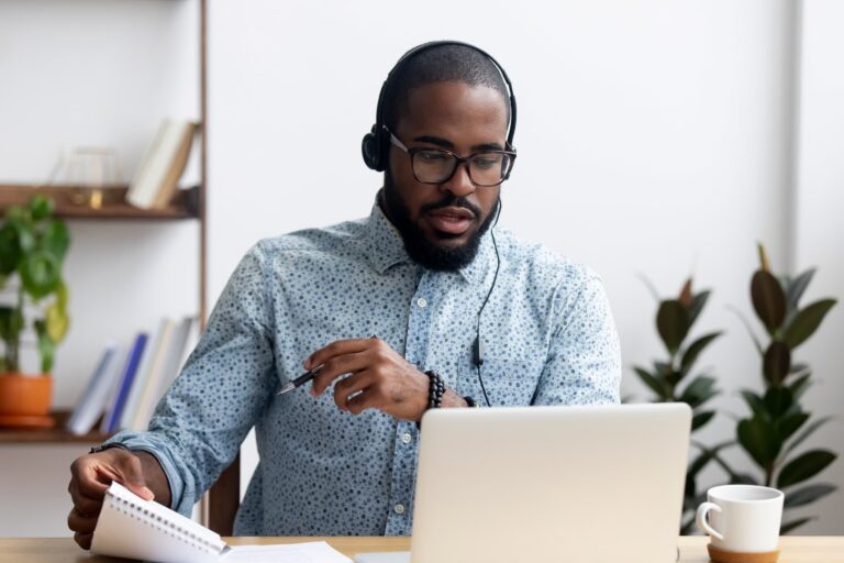 Man wearing headphones working remotely in a modern desk setting
