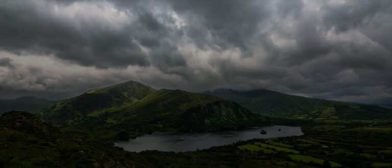 Cloudy dark sky over a green mountain terrain