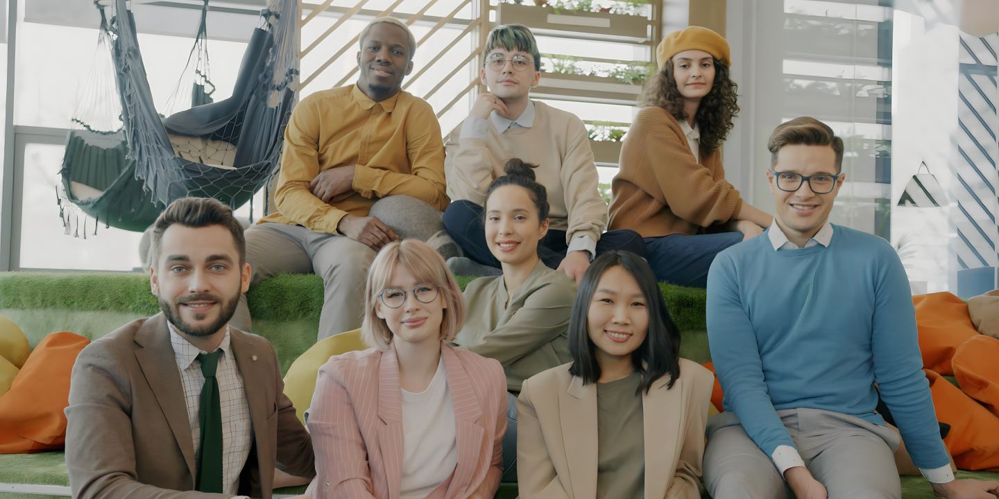 Group of colleagues gathered in a modern, collaborative workspace, reflecting a diverse and supportive workplace culture.