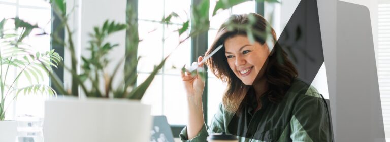 Person working at a desk with plants and a computer, representing streamlined Azure governance through effective resource management.