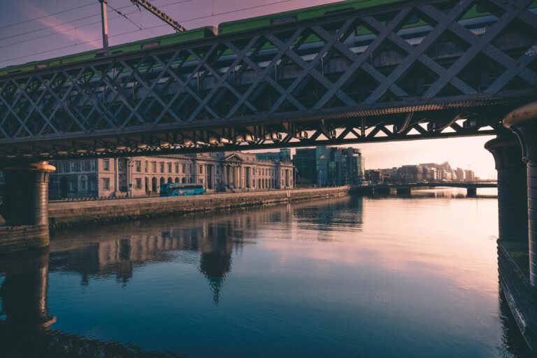 View of a river with a railway bridge and historic buildings along the waterfront, symbolising connectivity and secure productivity in an urban setting